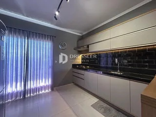 Vista da cozinha moderna com armários e bancadas escuras.