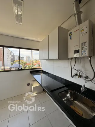 Vista da cozinha com bancada escura e azulejos brancos.