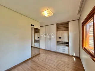 Sala de estar com piso de madeira e armários embutidos.