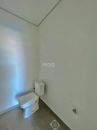 Foto de um banheiro interno com vaso sanitário branco e piso claro.