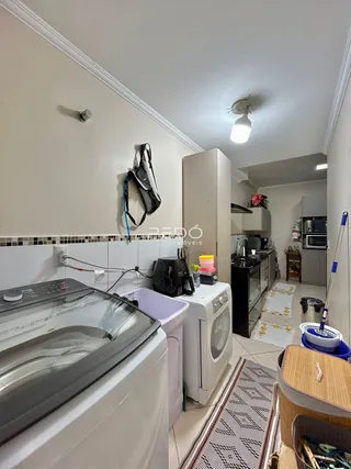 Cozinha com máquina de lavar e fogão visíveis na imagem.