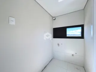 Vista interna de um corredor com paredes brancas e piso de cerâmica.