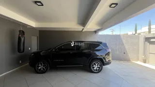 Fachada de uma residência com um veículo estacionado na frente.