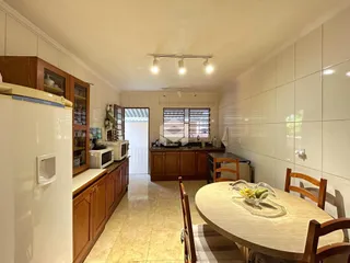 Foto de uma área de jantar com armários de madeira em um imóvel no Brasil.