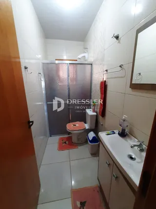 Corredor interno com revestimento cerâmico nas paredes e piso.
