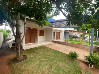 Fachada de uma residência em Lajeado, Brasil, com jardim gramado e árvores.
