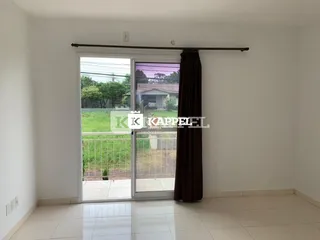 Sala de estar com porta de vidro que dá acesso a um quintal.