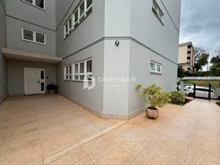 Vista externa de um pátio com piso de cerâmica em uma residência.