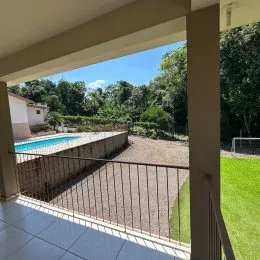 Varanda com vista para a piscina e jardim.