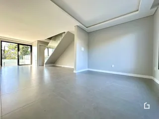 Ambiente interno amplo com piso de concreto polido e porta de vidro.