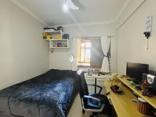 Quarto com cama e estante na sala.