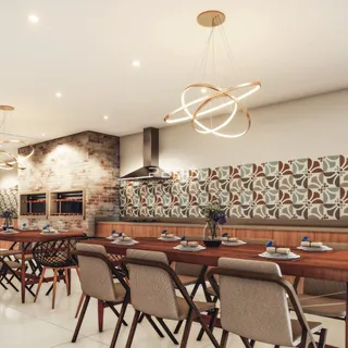 Uma sala de jantar com mesa de madeira e parede de tijolos exposta.