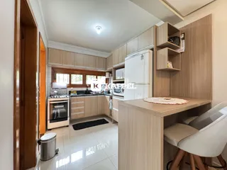 Cozinha moderna com armários de madeira e piso claro.