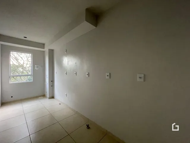 Vista interna de um corredor com piso de cerâmica e paredes brancas.