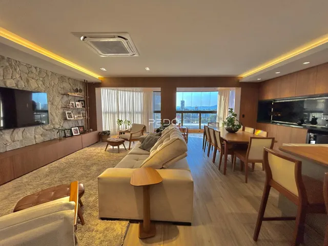 Sala de estar e jantar de um apartamento moderno com piso de madeira.