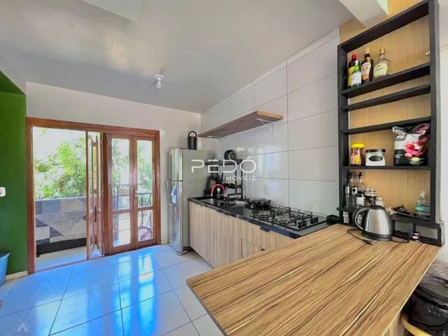 Vista da cozinha com piso azulejado e armários em um imóvel em Lajeado.