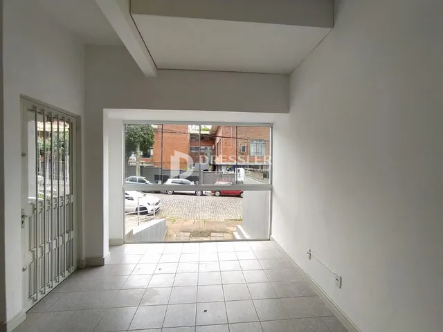 Hall de entrada com porta e vista para o pátio externo.