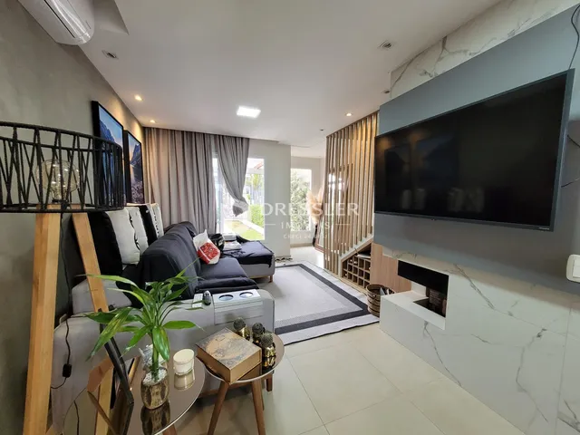 Sala de estar moderna com sofá e televisão em um apartamento no Brasil.