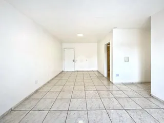 Corredor interno com piso de cerâmica e paredes brancas.