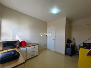 Foto de um cômodo interno com piso de madeira clara e armário na parede.