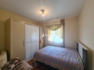 Quarto com cama e armário em ambiente interno.