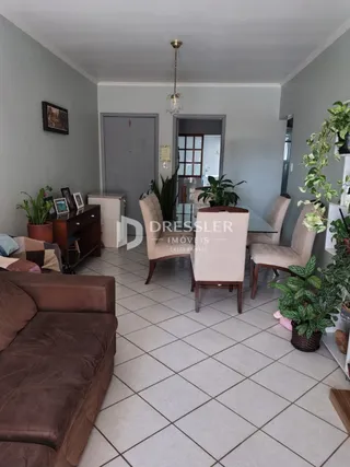 Sala de estar com piso de cerâmica e sofá marrom.