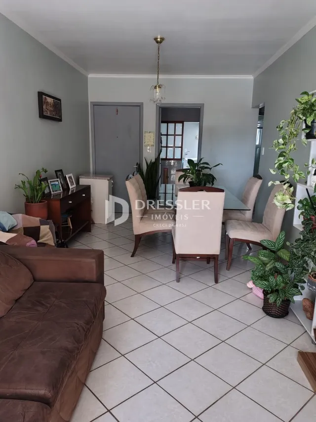 Sala de estar com piso de cerâmica e sofá marrom.