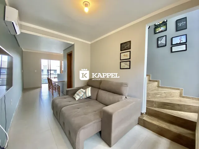 Sala de estar com um sofá grande e decoração de parede em um apartamento.