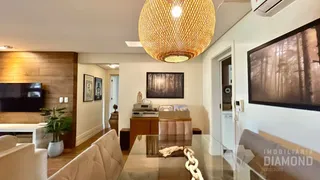 Sala de estar com painel de madeira e luminária grande.
