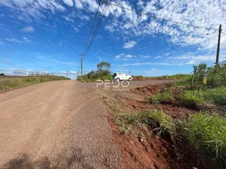Uma estrada de terra se estende sob um céu azul claro.