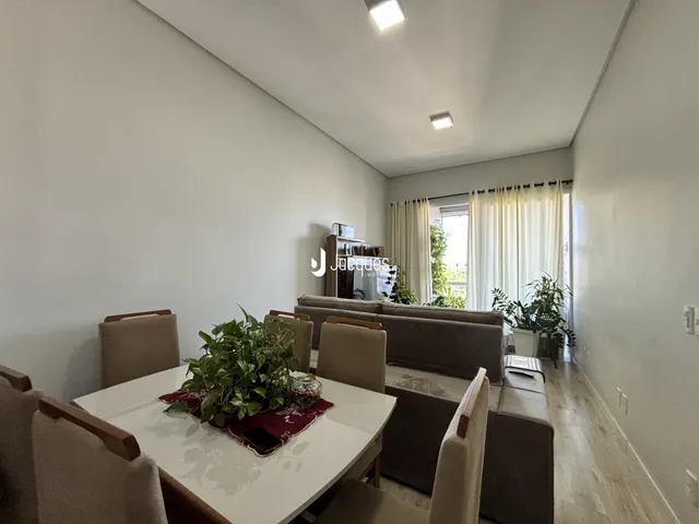 Sala de estar com sofá e mesa de jantar em um imóvel no Brasil.