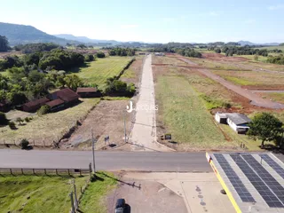 Vista aérea de uma propriedade rural com campos e estradas no Brasil.