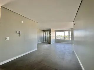 Ambiente interno de uma sala com paredes cinzas e piso de concreto.