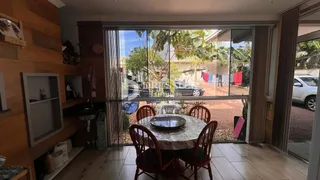 Sala de jantar com vista para o jardim externo através de portas de vidro.