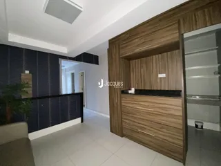 Interior de uma sala com revestimento de madeira e piso claro.
