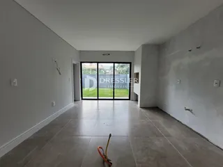Interior de um espaço com piso de concreto e porta de vidro.