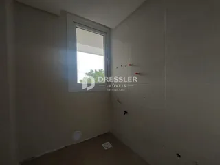 Vista interna de um ambiente com parede branca e janela em um imóvel.