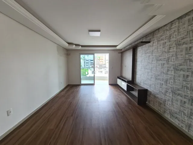 Vista de um ambiente interno com piso de madeira e parede texturizada.