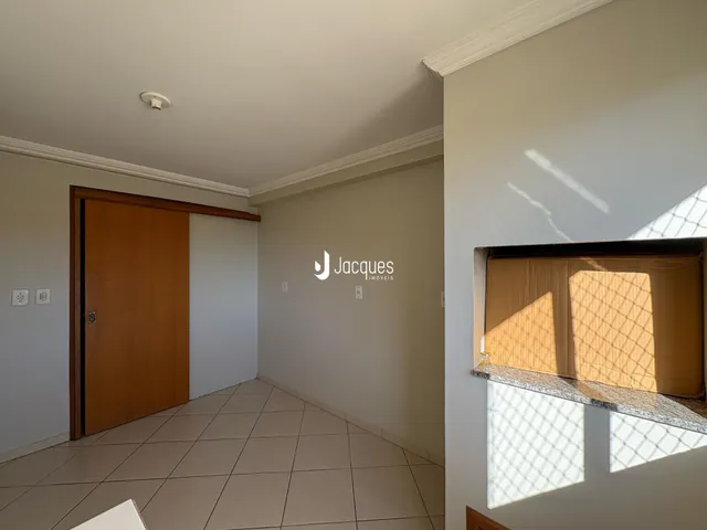 Vista interna de um ambiente com piso de cerâmica e porta de madeira.