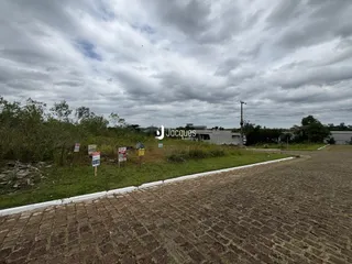 Vista externa de um terreno com vegetação e sinalização na frente.
