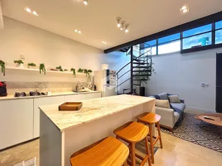 Cozinha moderna com ilha de mármore e acesso a uma área com vista.