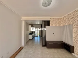 Hall de entrada com piso de cerâmica claro e parede texturizada.