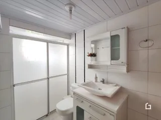 Foto de um banheiro moderno com louças sanitárias brancas.