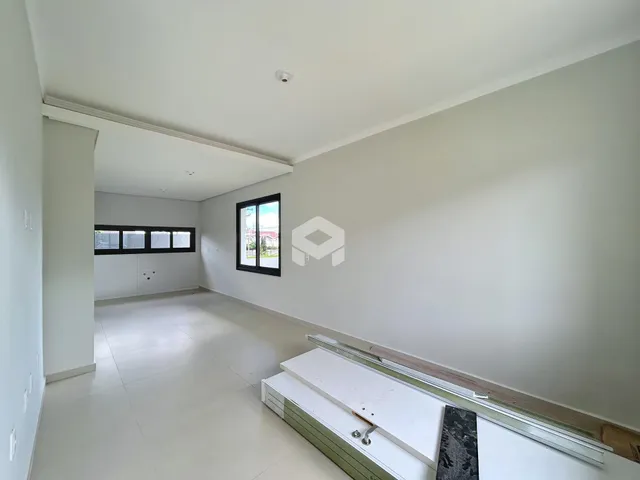 Hall de entrada com paredes brancas e piso claro.