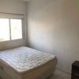 Foto de um quarto com cama e janela.