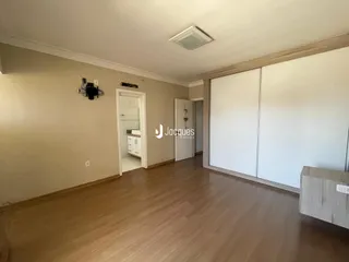Ambiente interno de uma sala com piso de madeira e armários embutidos.