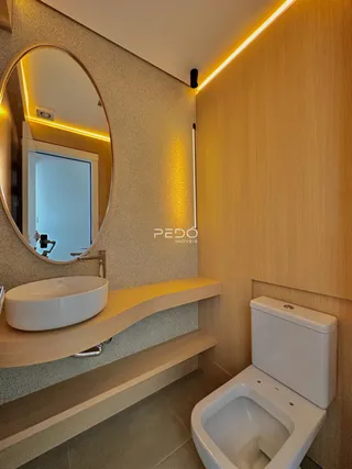 Foto de um banheiro moderno com pia e vaso sanitário.