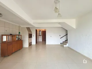 Ambiente interno de uma sala ampla com piso de cerâmica clara.