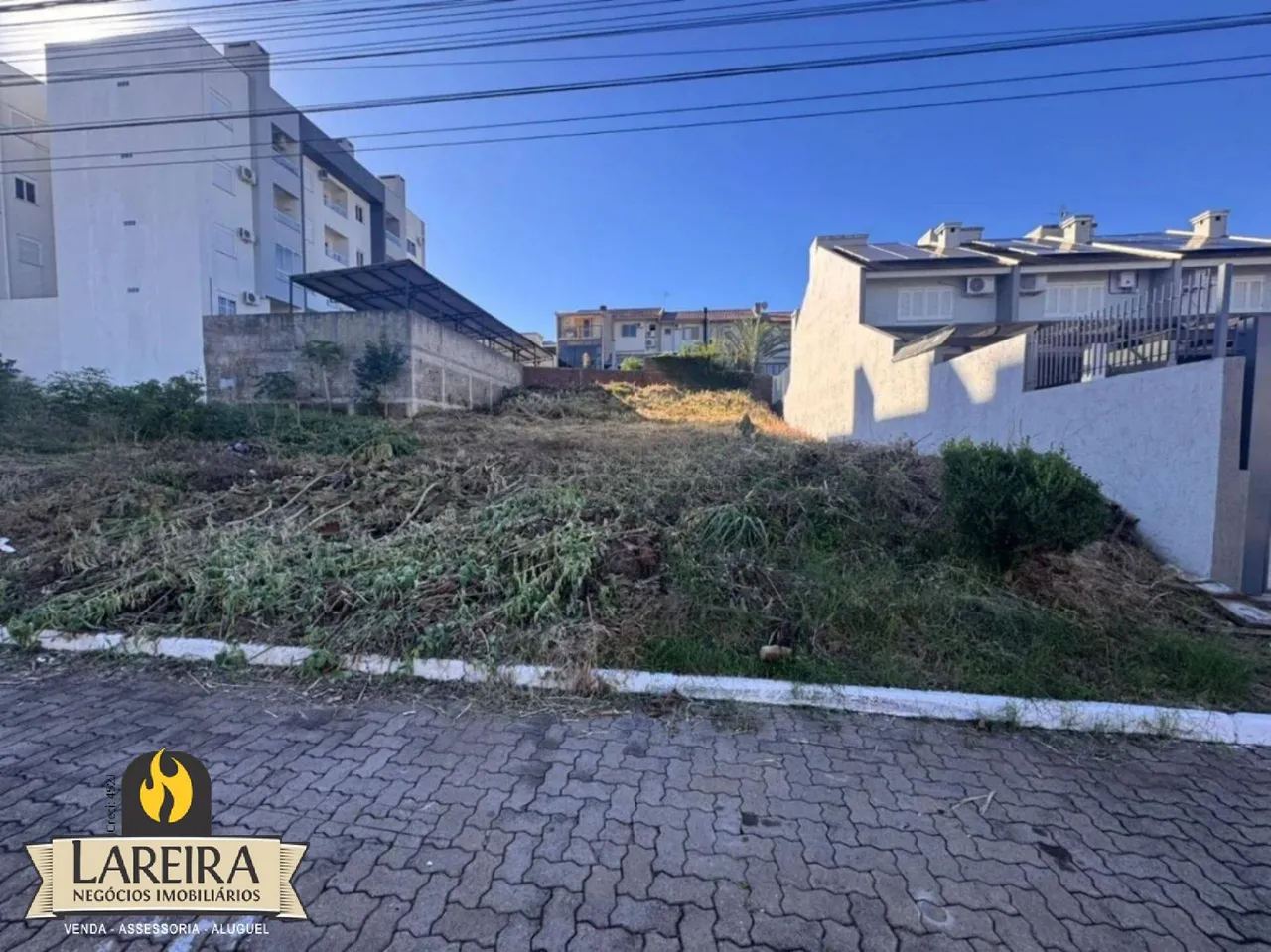 Vista externa de uma propriedade residencial em Lajeado, com vegetação alta na frente.