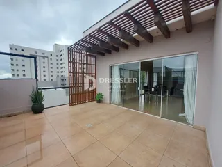 A foto mostra a área externa de uma residência com piso de cerâmica e uma estrutura de madeira.